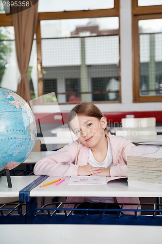 Image of Cute Girl Sitting With Books And Globe At Desk