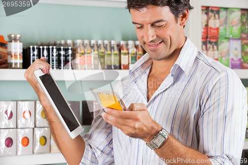 Image of Man With Digital Tablet Checking Product In Store