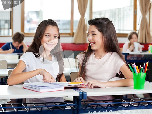 Image of Happy Schoolgirl Sitting With Friend At Desk