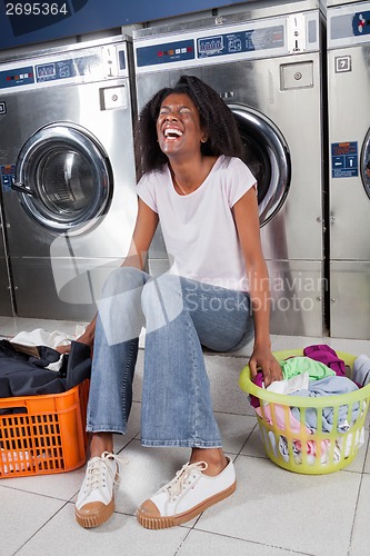 Image of Cheerful Woman Sitting In Laundry