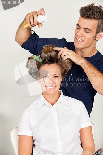 Image of Customer With Hairstylist Setting Curls With Hairspray