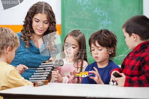 Image of Teacher Teaching Students To Play Xylophone In Class