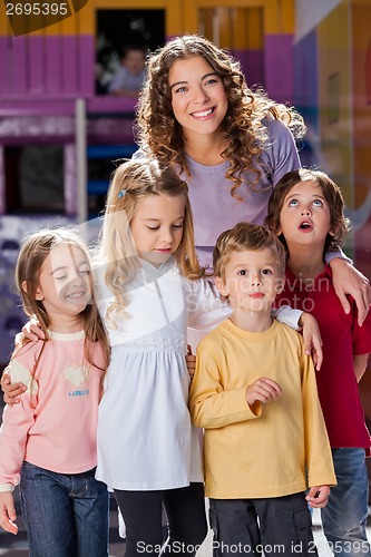 Image of Young Teacher With Children In Kindergarten