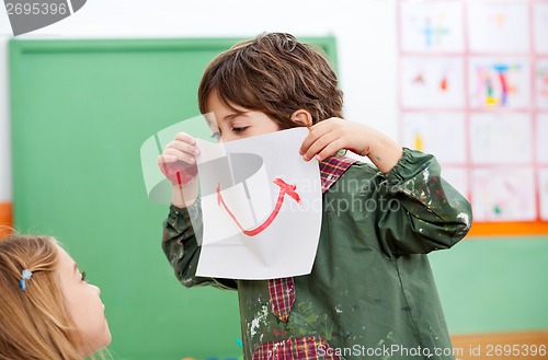 Image of Boy Holding Paper With Smile Drawn On It