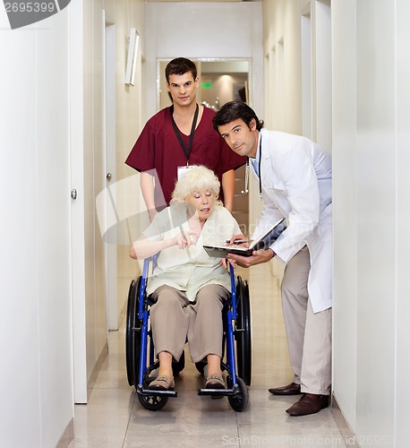 Image of Medical Professionals With Patient In Corridor