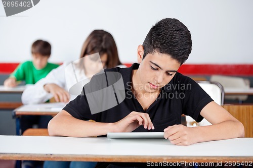 Image of Teenage University Student Using Digital Tablet At Desk