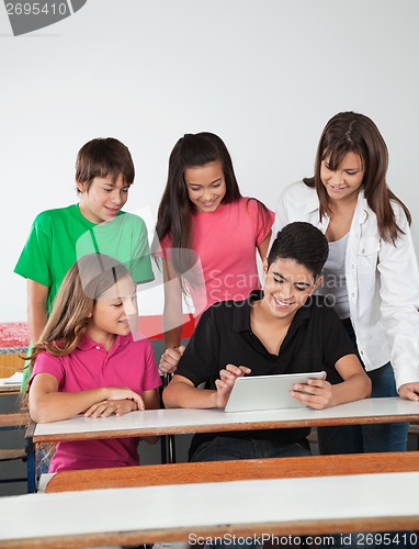 Image of Teenage Friends Using Digital Tablet At Desk