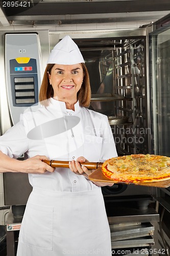 Image of Mature Female Chef Presenting Pizza