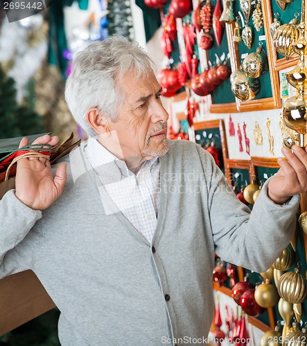 Image of Man Buying Christmas Ornaments At Store