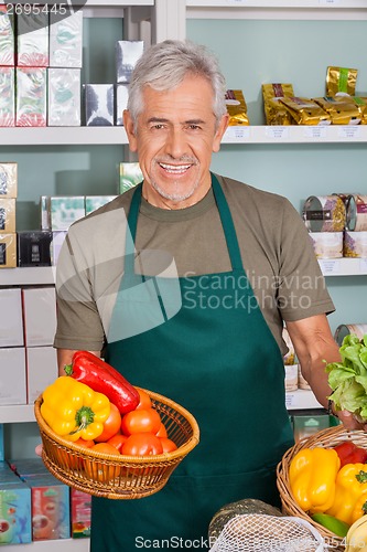 Image of Senior Salesman Holding Vegetable Basket