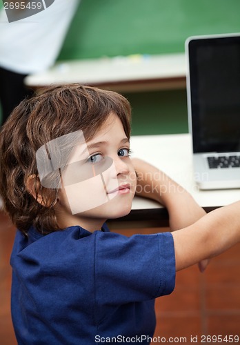 Image of Boy With Laptop On Desk In Classroom