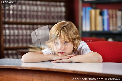 Image of Bored Schoolboy Leaning On Table In Library