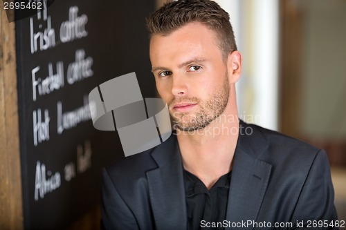 Image of Businessman Next To Chalkboard At Coffeeshop