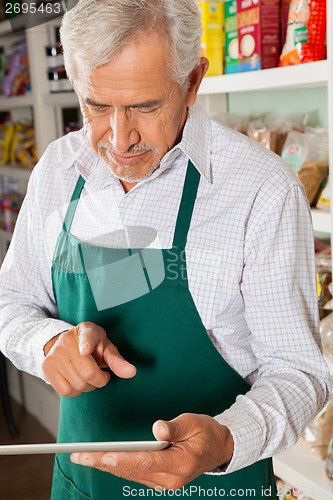 Image of Male Owner Using Digital Tablet