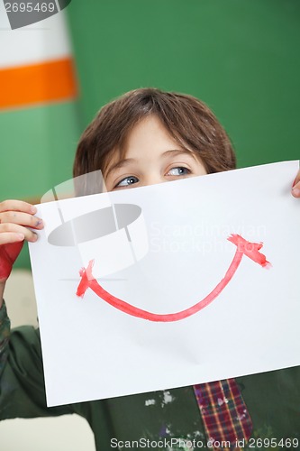 Image of Boy Holding Paper With Smile Drawn On It