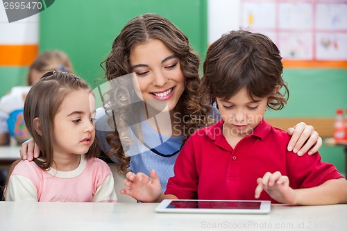 Image of Children Using Digital Tablet With Teacher