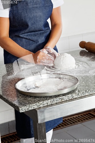 Image of Female Chef Kneading Dough On Counter