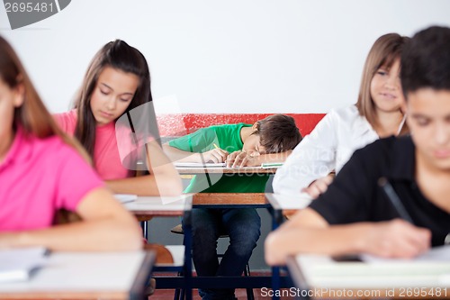 Image of Male Student Sleeping On At Classroom