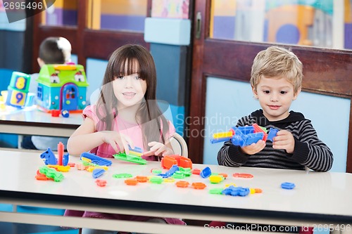 Image of Cute Girl With Friend Playing Blocks At Desk In Classroom