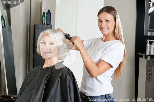 Image of Hairdresser Ironing Woman's Hair