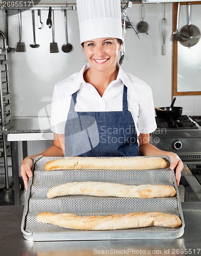 Image of Female Chef Presenting Loafs In Kitchen