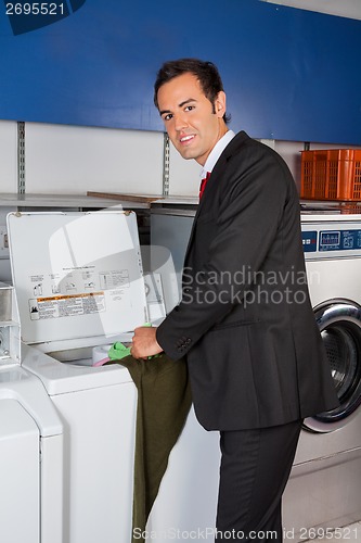 Image of Businessman Washing Clothes At Laundromat