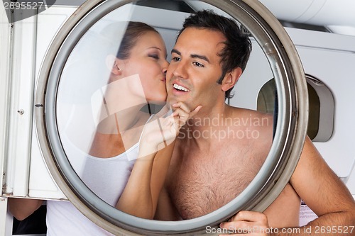 Image of Woman Kissing Man On Cheek In Laundry