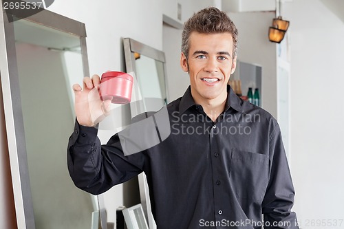 Image of Happy Hairstylist Showing Hairgel Bottle