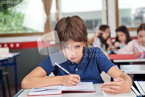 Image of Schoolboy Cheating At Desk During Examination