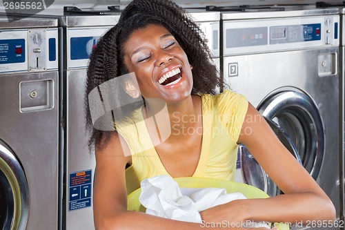 Image of Young Woman With Clothes Basket At Laundromat