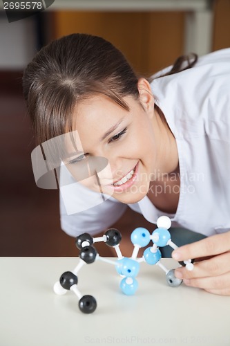 Image of Female Student Looking At Molecular Structure At Desk