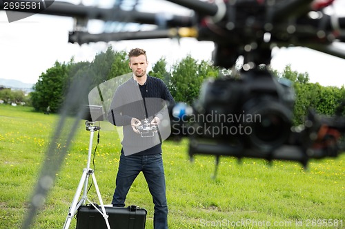 Image of Engineer Flying  UAV Helicopter in Park