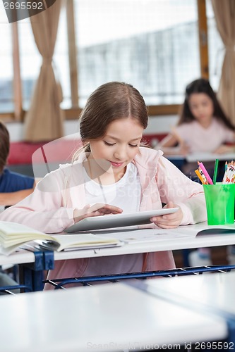 Image of Female Student Using Digital Tablet At Desk