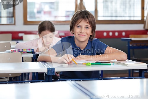 Image of Cute Schoolboy Sitting In Classroom