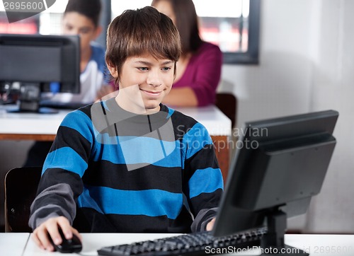 Image of Boy Smiling While Using Computer In Classroom