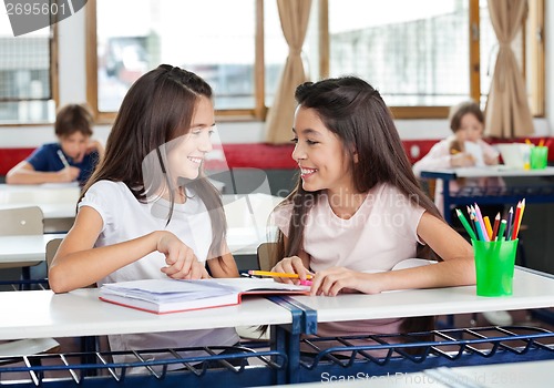 Image of Schoolgirls Looking At Each Other In Classroom