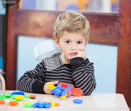 Image of Unhappy Boy With Blocks In Classroom