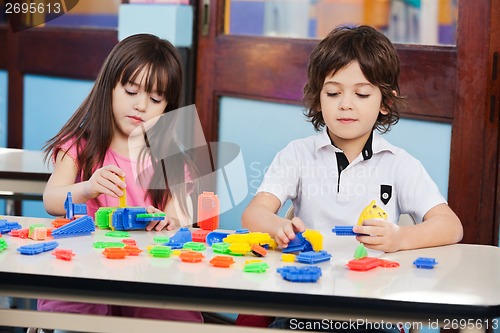Image of Children Playing With Construction Blocks At Desk