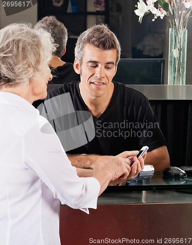 Image of Hairdresser And Client Discussing Over Mobilephone