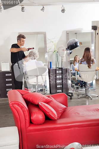 Image of Hairdresser Styling Customer's Hair At Parlor