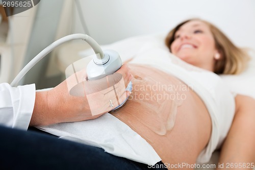Image of Female Doctor Scanning Pregnant Woman's Belly