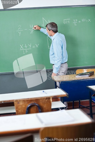 Image of Male Teacher Writing On Greenboard