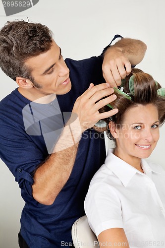 Image of Customer With Hairstylist Curling Hair At Parlor