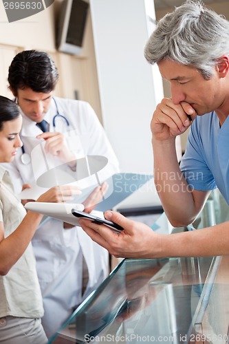 Image of Doctor Reading Document At Reception