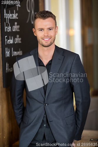 Image of Young Businessman Standing In Restaurant