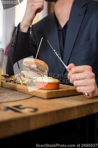 Image of Businessman Eating Food In Restaurant