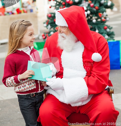 Image of Girl Giving Wish List To Santa Claus