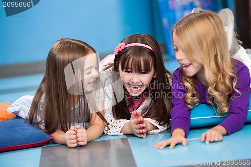 Image of Little Girls Laughing While Lying On Floor