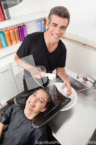 Image of Hairstylist Washing Client's Hair In Parlor