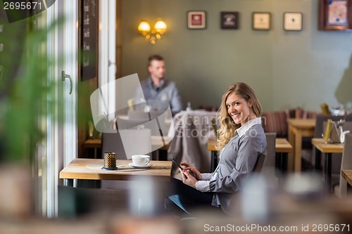 Image of Pregnant Woman Using Digital Tablet At Coffeeshop